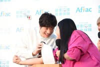 血圧測定の際、田中圭（左）を凝視するガンバレルーヤよしこ（右）。