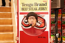 「テング ビーフステーキジャーキー」のロゴを突き破るひょっこりはん。