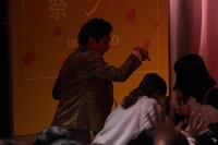 客席から登場するも遅れてきた観客と鉢合わせてしまい、座席まで案内する木崎。