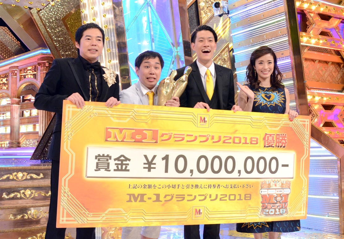 「M-1グランプリ2018」で優勝した霜降り明星と、司会の今田耕司（左）、上戸彩（右）。