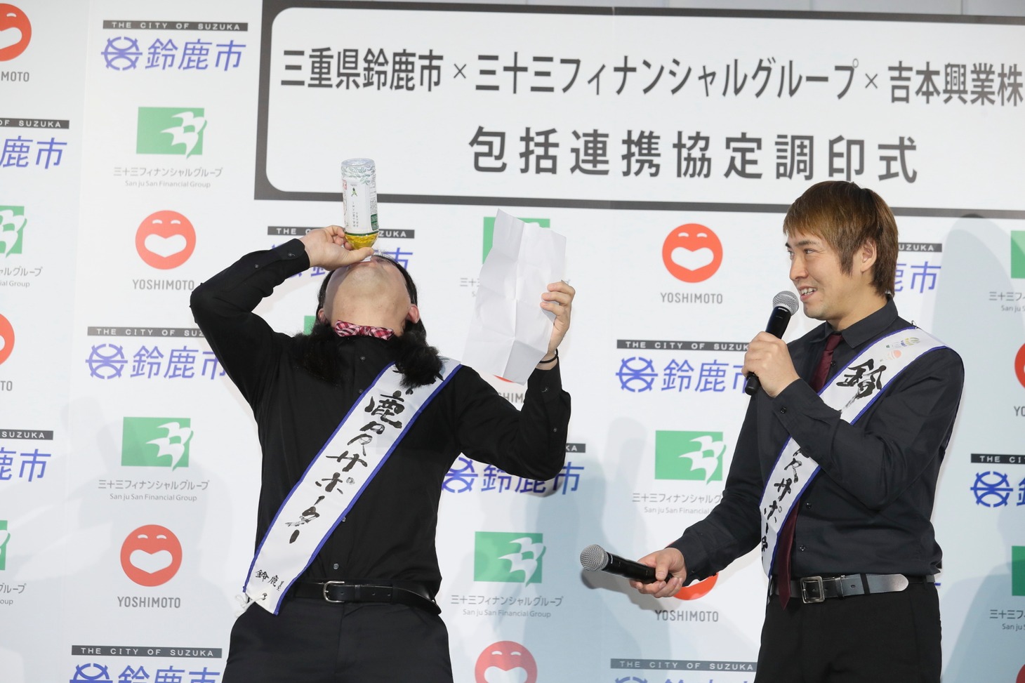 鈴鹿茶を一気に飲むハイキングウォーキング・鈴木Q太郎（左）。
