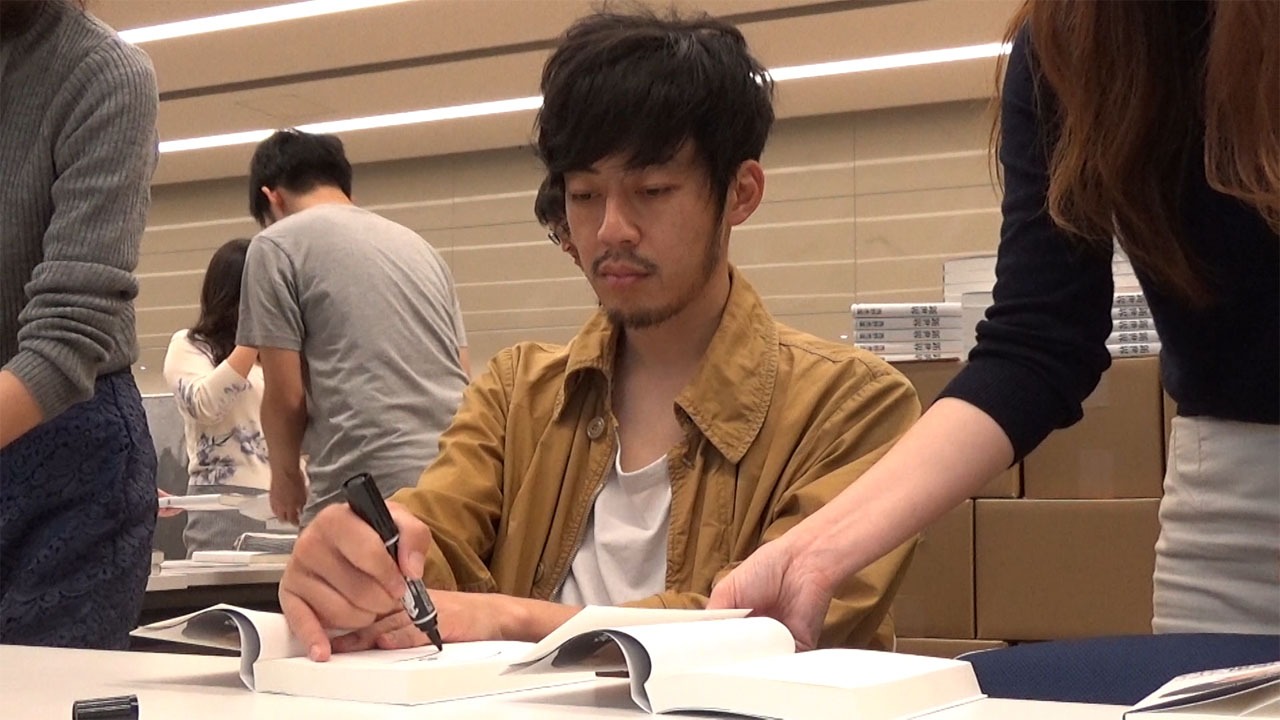 本にサインを入れる西野。(c)MBS