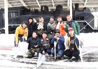 会津柳津駅にて、プラチナ5。後列左からアイロンヘッド辻井、ミキ亜生、バンビーノ藤田、ツートライブたかのり、ダブルアート真ベぇ、バンビーノ石山。前列左からツートライブ周平魂、ダブルアート・タグ、ミキ昴生、アイロンヘッド・ナポリ。