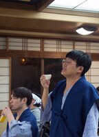 ミキ昴生の熱唱ぶりを、酒を飲みながら見ているミキ亜生（右）。