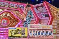優勝賞金500万円や副賞と並んで写真撮影に応じる霜降り明星・粗品。
