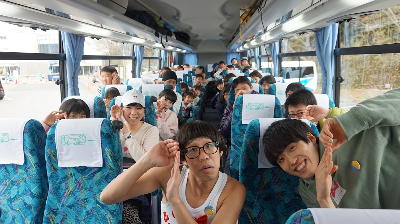 バスで記念撮影する一同。