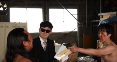 ロバートが出演する「朝の連続刑事ドラマ小説 裸で銃を持つ男」のワンシーン。