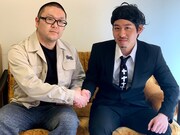「咳暁夫AI」開発者・竹之内大輔氏(左)と握手を交わすMr.ドーナツ伝説 咳暁夫(右)。