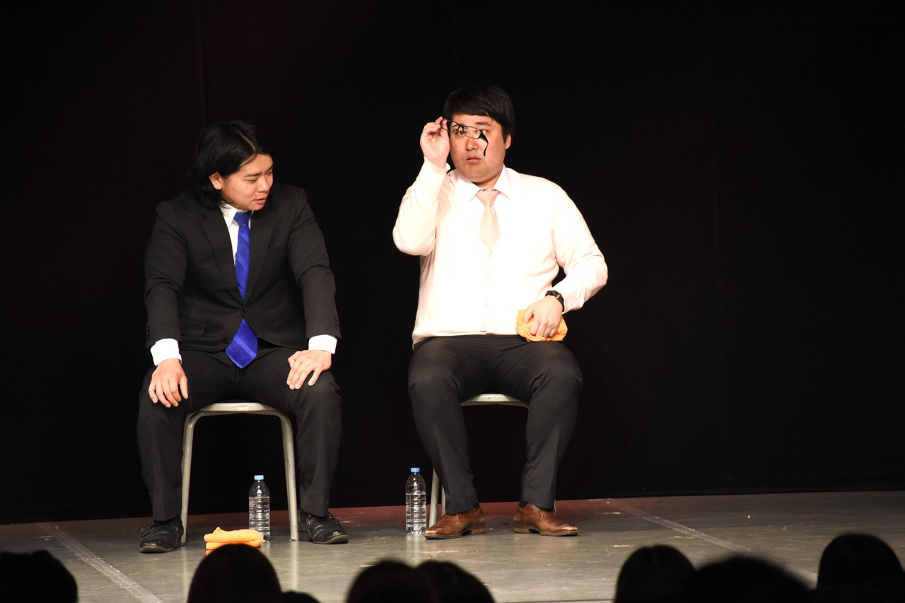 休憩中にメガネを拭く村上（右）。