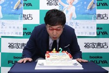 会場に用意された誕生日ケーキの火を消す南海キャンディーズ山里。