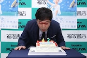会場に用意された誕生日ケーキの火を消す南海キャンディーズ山里。
