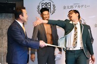 とろサーモン久保田のモノマネで、金太郎ホームの代表取締役・佐々木氏（左）へ礼を述べるプラス・マイナス兼光（右）。