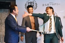 とろサーモン久保田のモノマネで、金太郎ホームの代表取締役・佐々木氏（左）へ礼を述べるプラス・マイナス兼光（右）。