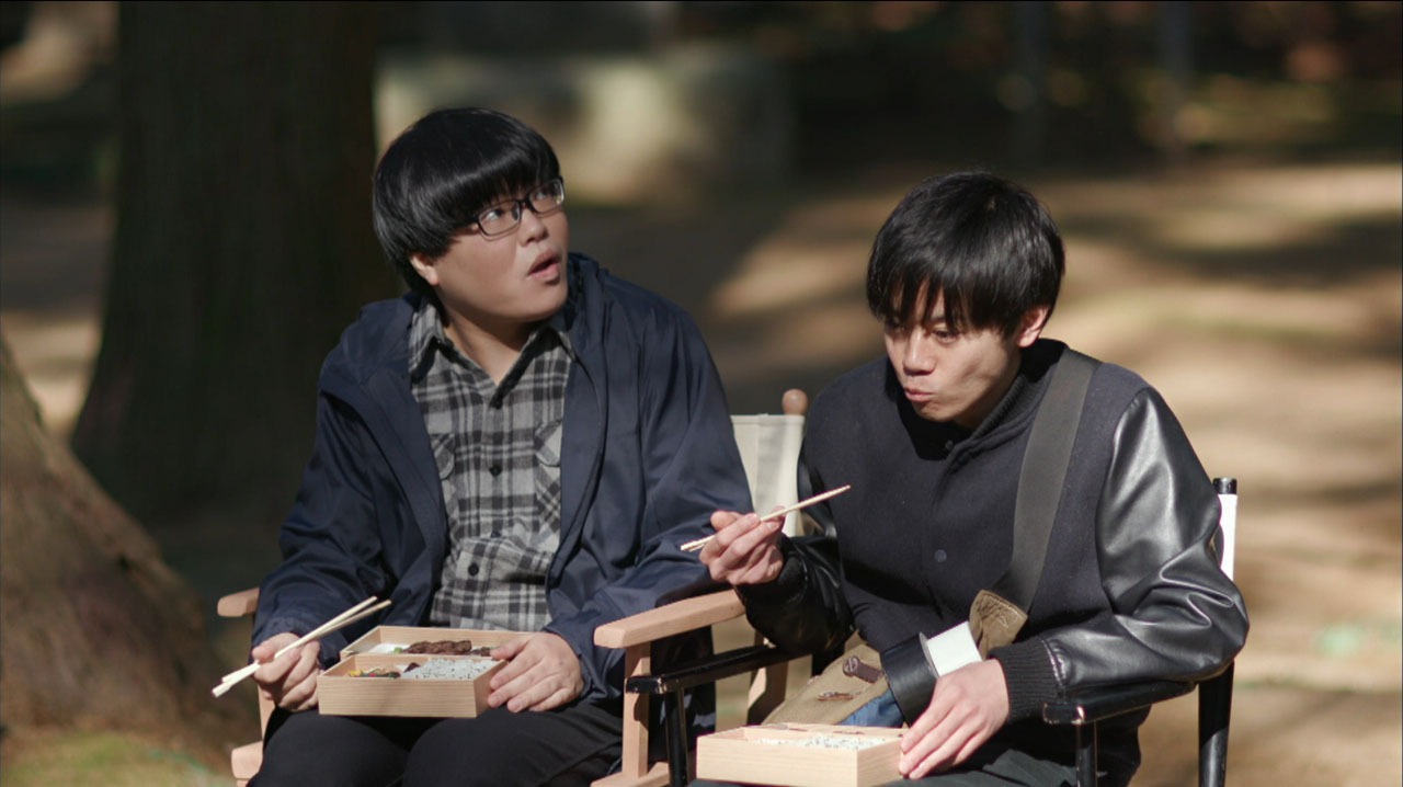 AD役のライス関町（左）は弁当を食べている。(c)テレビ東京