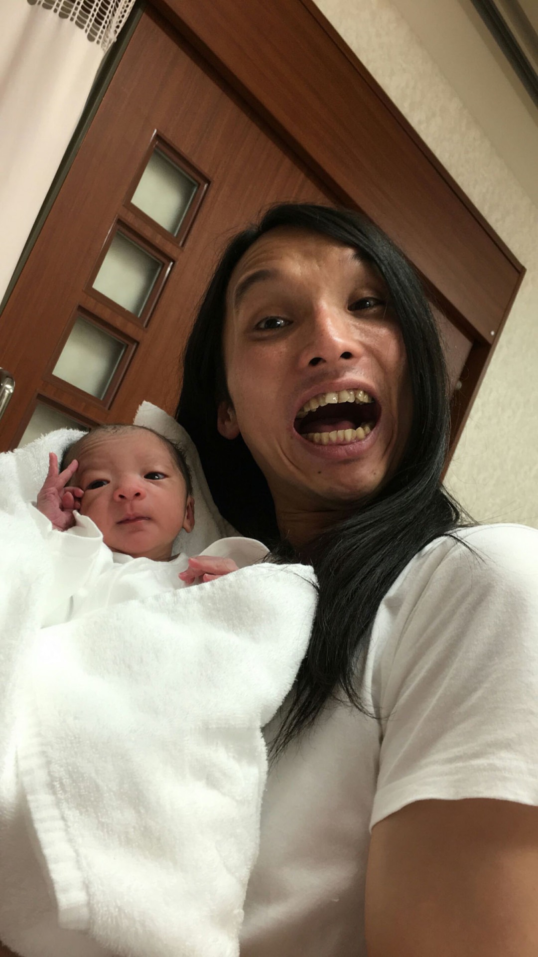 生まれたばかりの娘を抱くトム・ブラウン布川。