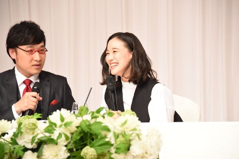 船場吉兆の記者会見スタイルで蒼井優に言わせたいことをささやく南海キャンディーズ山里(左)。