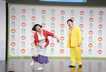 会見を観に来た観客にアメちゃんを撒くすっちー（左）。