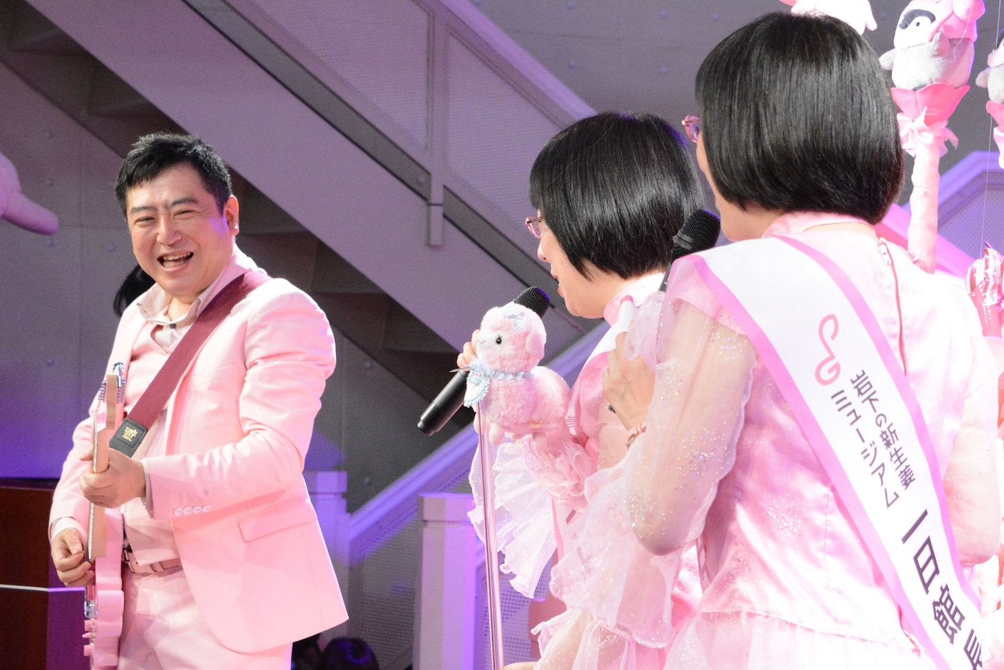 岩下和了社長（左）のギター演奏に合わせて歌う阿佐ヶ谷姉妹（右）。