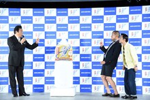 高橋英樹（左）からお中元として天海の水1年分を贈られるカミナリ。