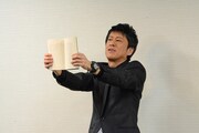 自著の紙面を見せるブラックマヨネーズ吉田。