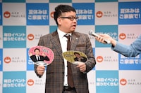 販売されるミキのうちわ。裏表に昴生と亜生の写真がプリントされており、「売れ残らない！」と昴生。