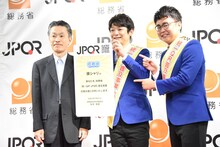 JPQR広報大使に就任した銀シャリと総括審議官・秋本芳徳氏（左）。
