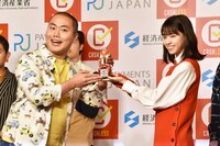 ハナコ岡部（左）が西野七瀬（右）から「ハナマル面白かったで賞」のトロフィーを授与された場面。