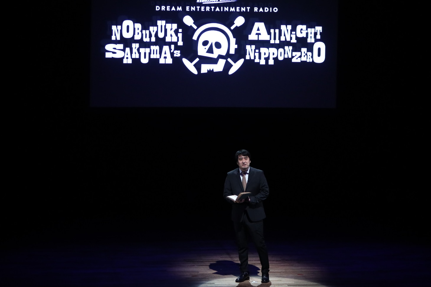 オープニングで演劇人の名言を朗読する佐久間P。