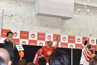 飴と共に合格者の記載された紙が封入された小袋をオーディション参加者たちへ投じる（左から）ビスケッティ佐竹、キャベツ確認中しまぞうZ、レイザーラモンRG。