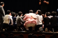 客席を背景とした集合写真撮影の様子。