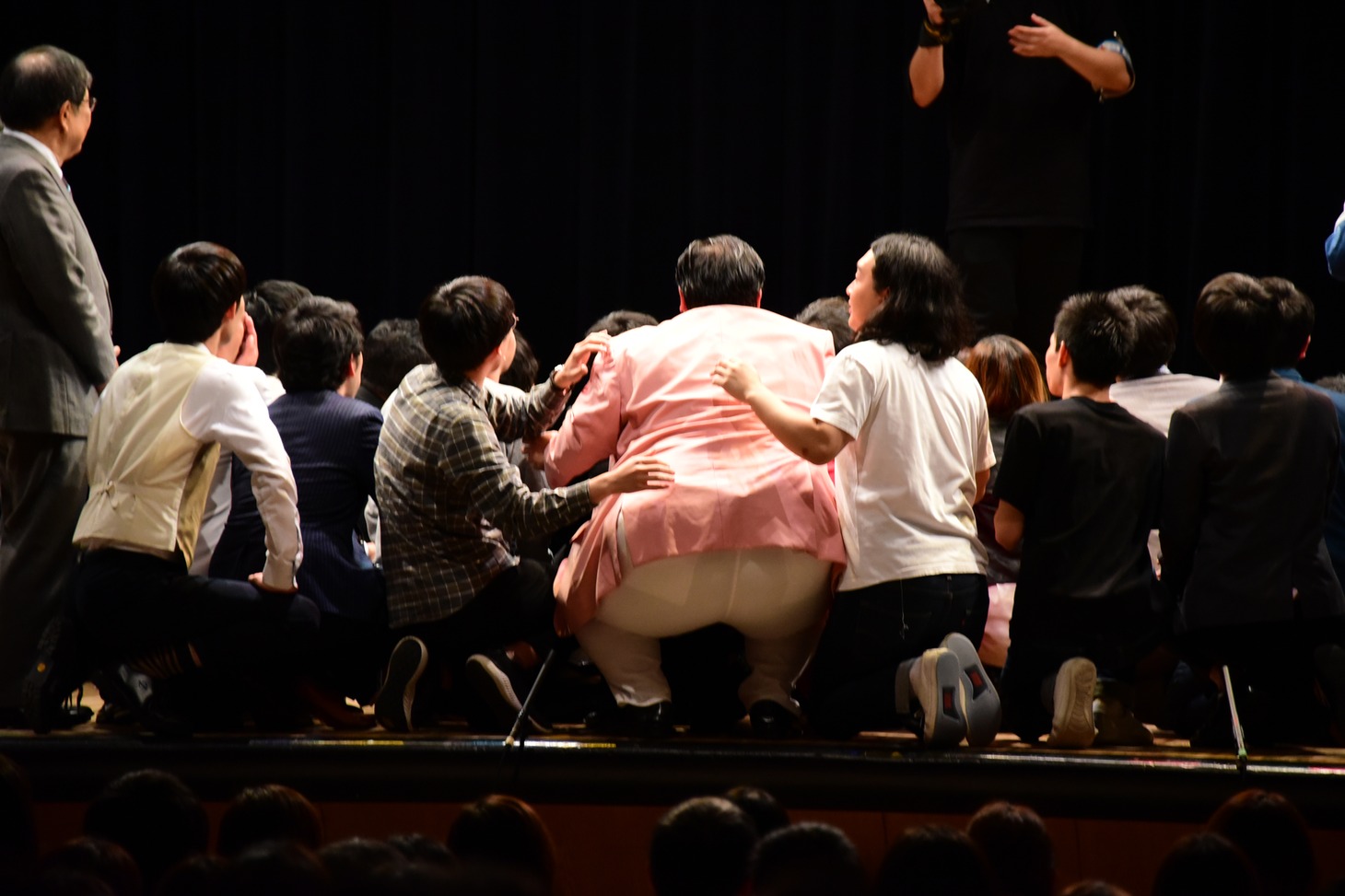 客席を背景とした集合写真撮影の様子。