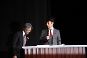 井上肇氏（左）に厳しい態度をとる藤井隆（右）。