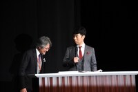 井上肇氏（左）に厳しい態度をとる藤井隆（右）。