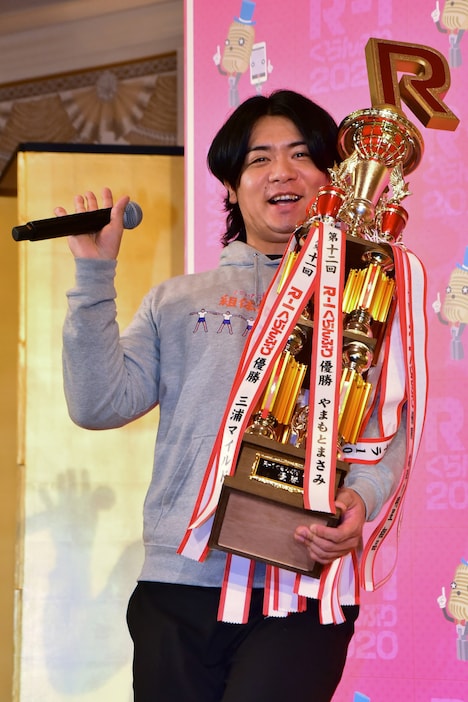 取材陣に笑顔で手を振りながら会見場に登場する、マヂカルラブリー・野田クリスタル。