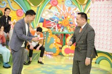 ミルクボーイ内海（右）が駒場（左）に「好きなところ100BOOK」を手渡すワンシーン。(c)ABCテレビ