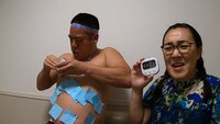 「30秒間で体に付箋を最も多く貼る世界記録」に挑むチェリー吉武（左）。(c)ABCテレビ