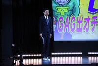 「普段はスーツを着ないのに急にスーツを着ることになったから靴までは間に合わなかった人」の扮装で登場したコーナー司会のGAG宮戸。