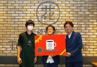 「第1回 笑ラッテ飲んでタグって大賞」の特典を受け取るアインシュタイン（右）。