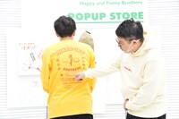 ロングTシャツにプリントされているキーワードを1つひとつ説明するミキ昴生。