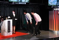 「ど～んと優勝記念像」を凝視するマヂカルラブリー。