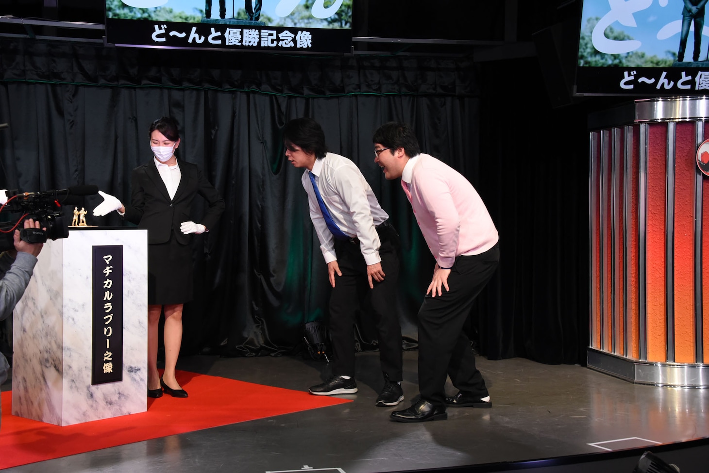 「ど～んと優勝記念像」を凝視するマヂカルラブリー。