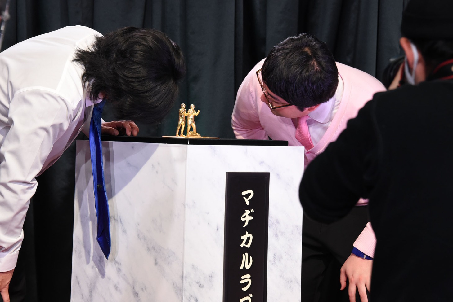 「ど～んと優勝記念像」を凝視するマヂカルラブリー。