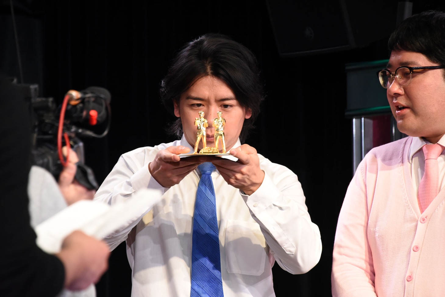 「ど～んと優勝記念像」を凝視するマヂカルラブリー野田クリスタル（左）。