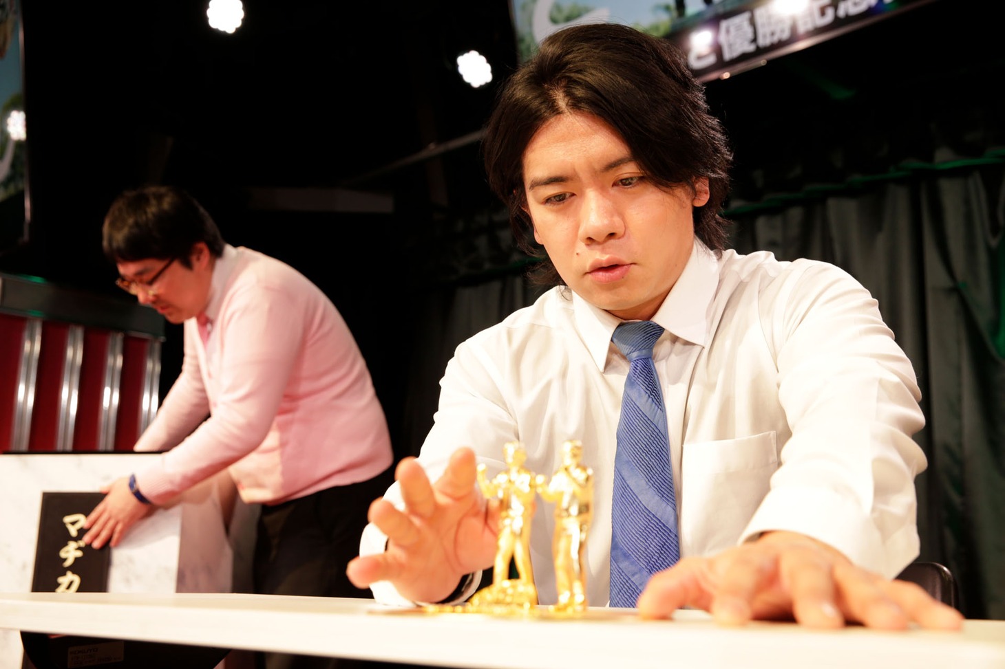 「ど～んと優勝記念像」をまじまじと見る野田クリスタル（右）と、台座をまじまじと見る村上（左）。