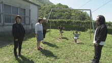 2019年山口県上関町の旅より、休校中の校庭で遊ぶ家族に話しかけるピース又吉。