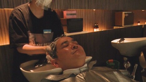 プライベートで通う美容室で、番組ディレクターから報告を受ける千鳥ノブ。(c)テレビ朝日