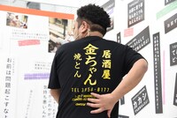 居酒屋金ちゃんTシャツを紹介する金ちゃん。
