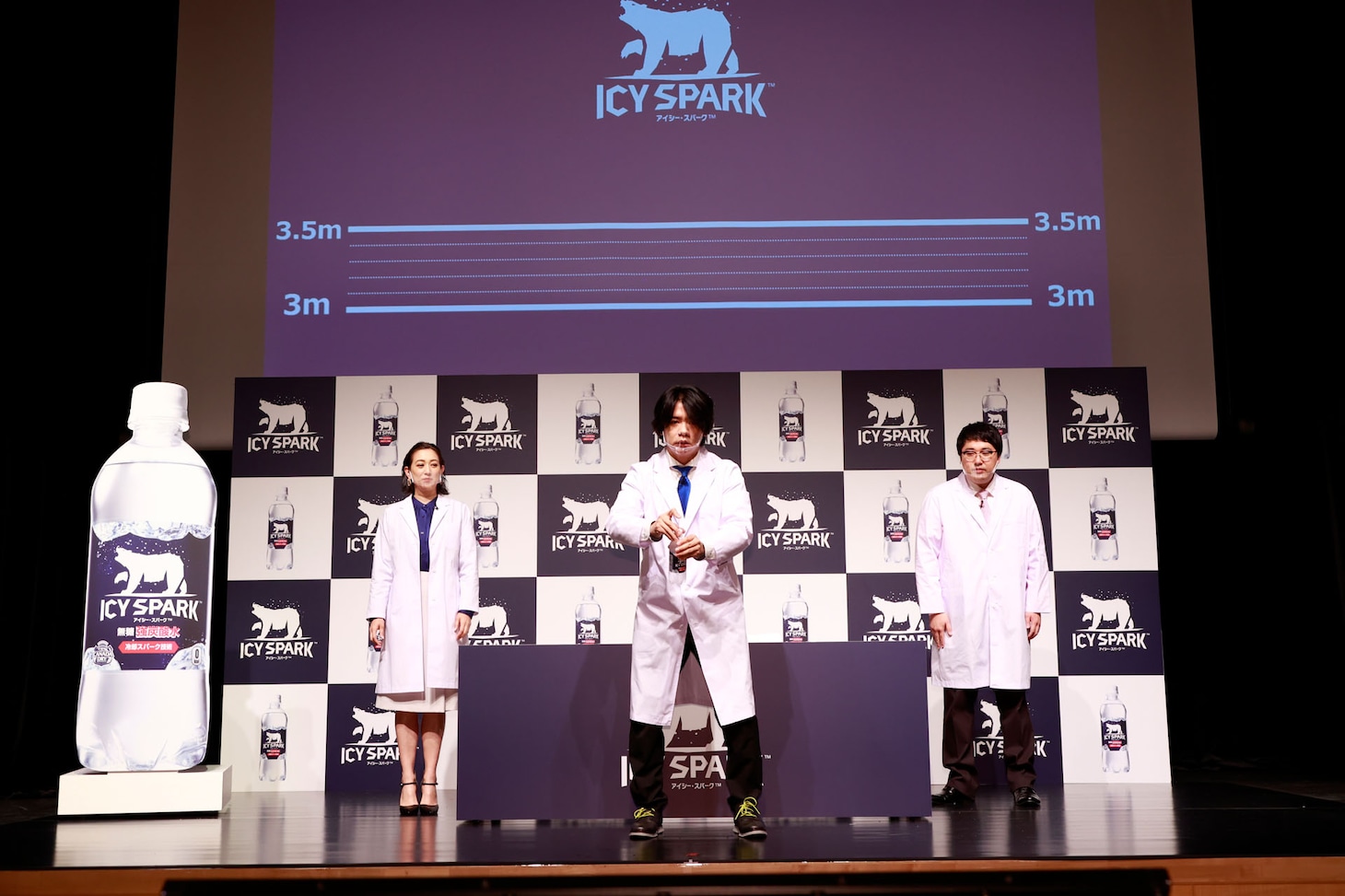 アイシー・スパークの入ったペットボトルをセットするマヂカルラブリー・野田クリスタル（中央）。