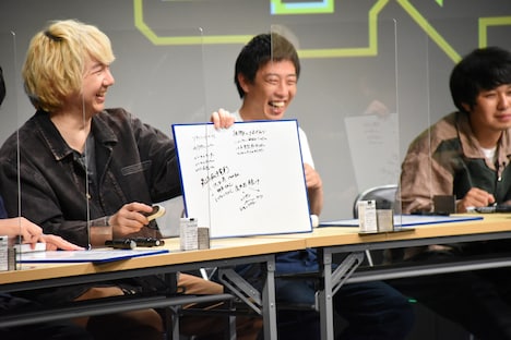 板書を写したホワイトボードを見せる三四郎・相田（左）。