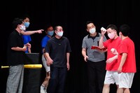 「空き缶積み対決」の様子。